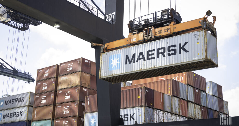 Container ship unloading cargo at a major port as global container rates fall