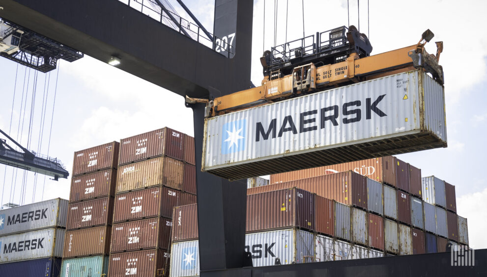 Container ship unloading cargo at a major port as global container rates fall