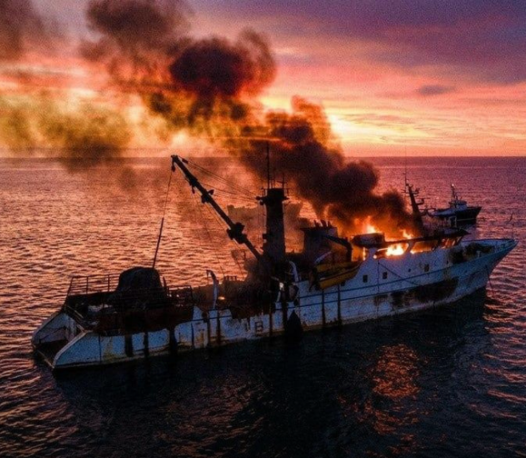 Container ship on fire after a maritime attack at sea, illustrating growing security risks for global shipping and international supply chains